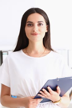 Indian woman worker portrait holding clipboard in hand smiling and looking at camera