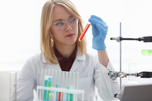 Technician hold in arms in protective gloves sample bottle with poison fluid portrait. Medical worker in uniform use reagent tube for virus infection exam or biological toxic reaction drug creation