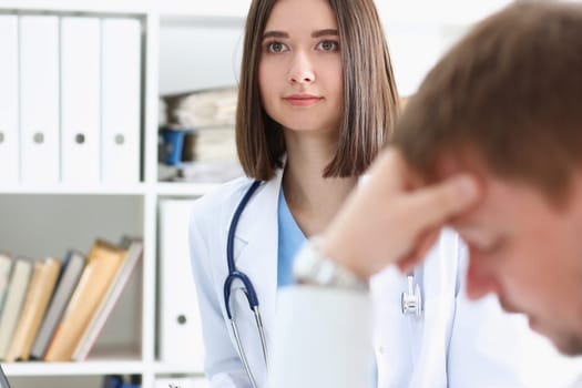 Friendly female doctor hold patient shoulder in office during reception. Examination result positive test calm down promise and cheer up grief and suffer treatment condolence ethics concept
