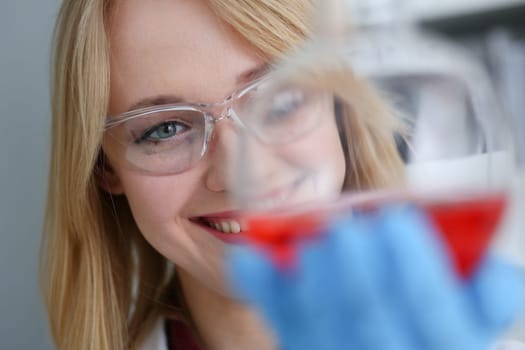 Technician hold in arms in protective gloves sample bottle with poison fluid portrait. Medical worker in uniform use reagent tube for virus infection exam or biological toxic reaction drug creation