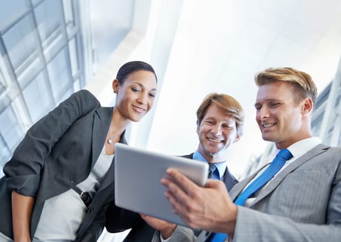 Excited about this new contract. A young businessman showing his colleagues something on a tablet