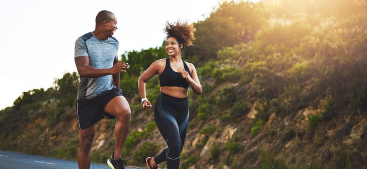 Fitness, exercise and couple running in nature by a mountain training for a race, marathon or competition. Sports, health and athletes or runners doing an outdoor cardio workout together at sunset