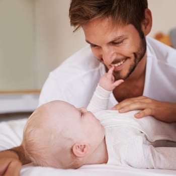 Hanging out with dad. a young father and his infant child bonding on a bed
