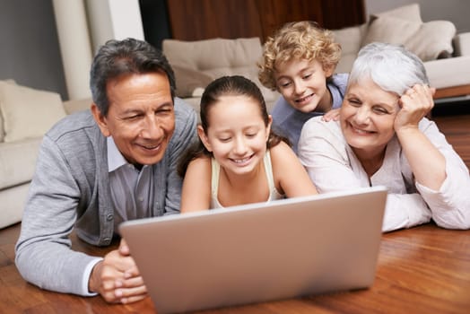 Laptop, relax or grandparents with happy kids for movie streaming online subscription in a family at home. Children siblings, floor or grandmother watching videos in retirement with a senior old man.