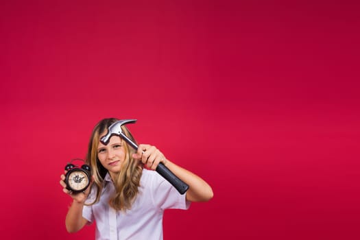 Kid girl holding hammer and alarm clock smiling with happy and cool smile on face. showing teeth.