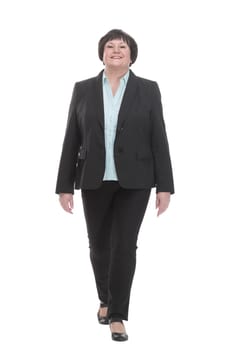 Mature business woman in a pantsuit striding forward. isolated on a white background.