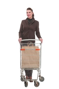 Full length portrait of a woman pushing a shopping trolley isolated on white background