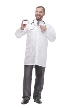 in full growth. smiling doctor showing his visiting card . isolated on a white background.