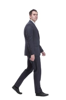 picture of a young business man wearing black suit walking forward - side view