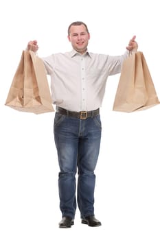 Good looking young man holding shopping bags, standing isolated over white background