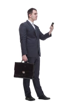 Front view of handsome young business man talking on a mobile phone and holding a suitcase on white background