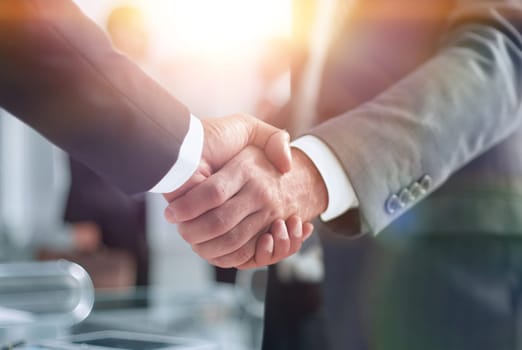 closeup of handshake of business partners on the background of business team