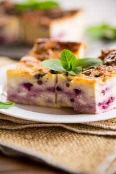 cooked cottage cheese casserole with berry filling in a plate on the table