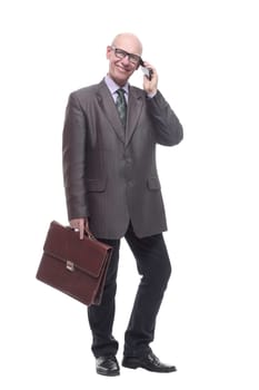 in full growth.smiling business man with a smartphone. isolated on a white background.