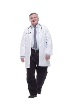 in full growth. competent doctor in a white coat striding forward. isolated on a white background.