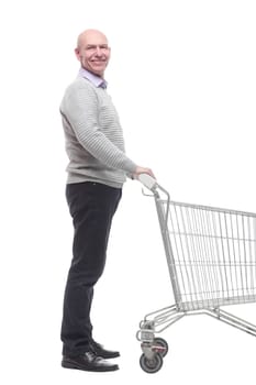 in full growth. a happy man with a shopping cart. isolated on a white background.