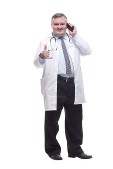in full growth. smiling doctor with a smartphone. isolated on a white background.