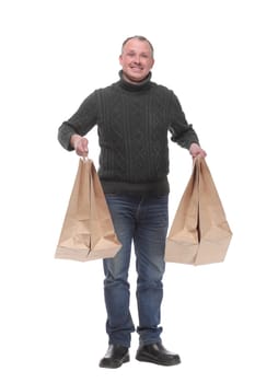 Full length portrait of a young casual man holding shopping bags isolated against white background