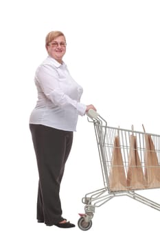 Full length portrait of a woman pushing a shopping trolley isolated on white background