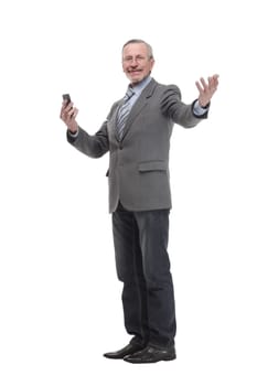 Portrait of a happy mature man dressed in suit holding mobile phone and looking at camera isolated over white background