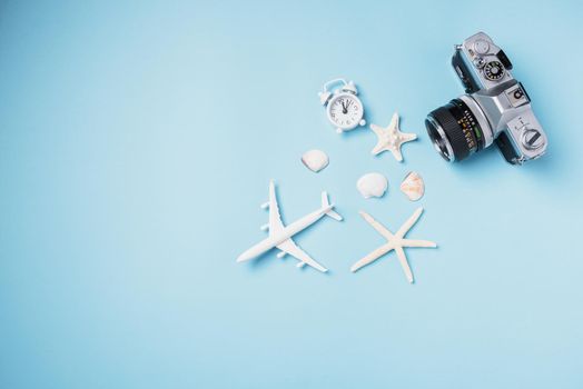 Flat lay top view mockup retro camera films, airplane, starfish, shells traveler tropical accessories isolated on a blue background with copy space, Business trip, and vacation summer travel concept