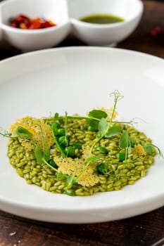 Pea risotto on a white porcelain plate in a fine dining restaurant