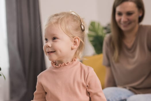 Deaf kid with hearing aid cochlear implant have fun with parents - Hear aid and medicine innovating technology and diversity