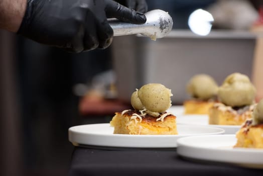 Chief preparing portokalopita, greek orange cake made with shredded filo, greek yoghurt, and olive oil with vanilla ice cream. Mediterranean cuisine dessert.