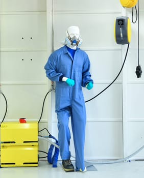 Dummy mannequin in respiratory mask and uniform in the area for car coloring