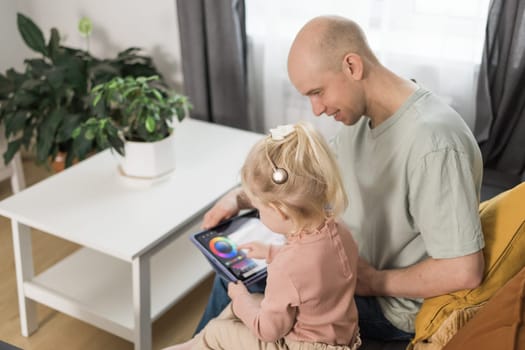 Funny baby with cochlear implant sitting at home and eating. Hear aid and medicine innovating technology and diversity concept