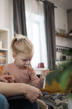 Funny baby with cochlear implant sitting at home and eating. Hear aid and medicine innovating technology and diversity concept