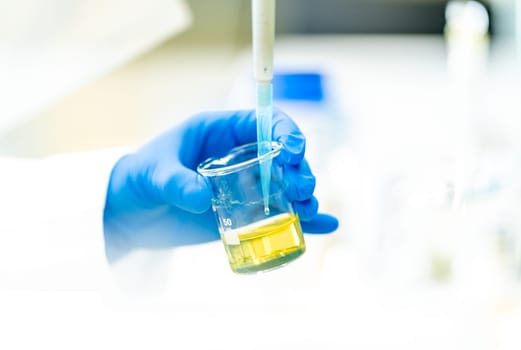 pipetting a chemical sample into research flasks. High quality photo