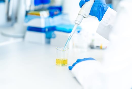pipetting a chemical sample into research flasks. High quality photo