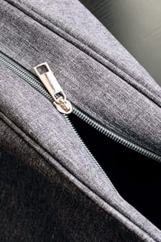 Open gray travel bag on a wooden background close up