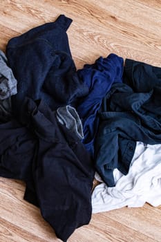 A pile of dirty clothes on a wooden floor