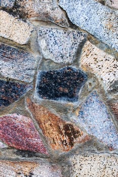 Wall of large colored stones close up, background or texture