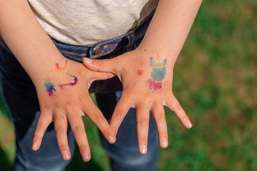 Shimmering sparkling glitter tattoo on a child's hand at a birthday party. Body art