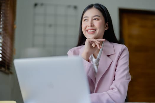 Excited businesswoman using computer laptop while in office, business concepts