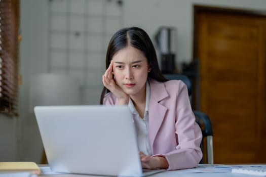 Portrait of business owner, woman using computer and financial statements Anxious expression on expanding the market to increase the ability to invest in business.