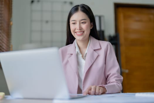 Excited businesswoman using computer laptop while in office, business concepts