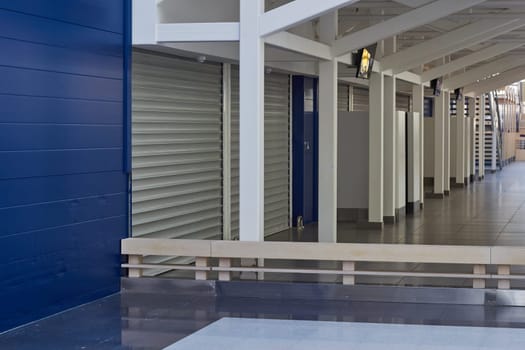 Closed retail space lowered roller shutters. Sales in a shopping center. No visitors. No buyers.