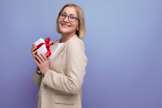 happy mature woman in jacket received holiday gift on studio background with copy space.