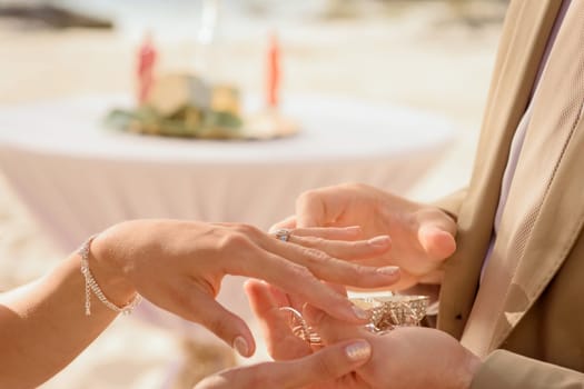 Newlyweds exchange rings, groom puts the ring on bride's hand