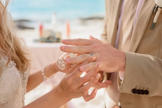 Newlyweds exchange rings, groom puts the ring on bride's hand