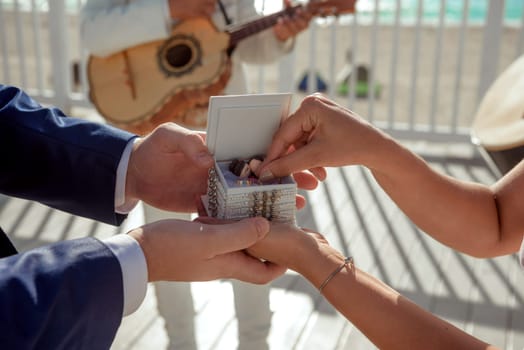 Newlyweds exchange rings, groom puts the ring on bride's hand