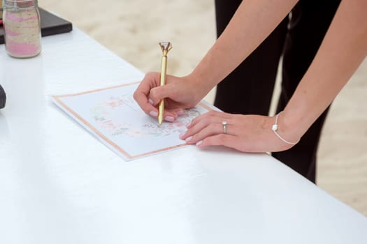 The bride signs the certificate of marriage.