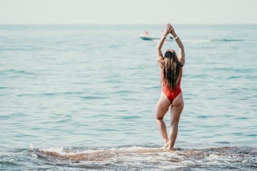 Woman sea yoga. Back view of free calm happy satisfied woman with long hair standing on top rock with yoga position against of sky by the sea. Healthy lifestyle outdoors in nature, fitness concept.