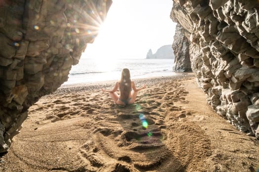 Middle aged well looking woman with black hair doing Pilates with the ring on the yoga mat near the sea on the pebble beach. Female fitness yoga concept. Healthy lifestyle, harmony and meditation.