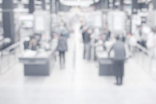 Abstract blurred background with people at grocery store checkout counters.