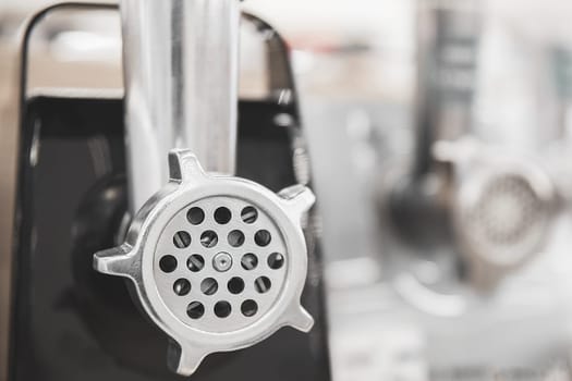 Meat grinder close-up in the store against the background of other meat grinders.